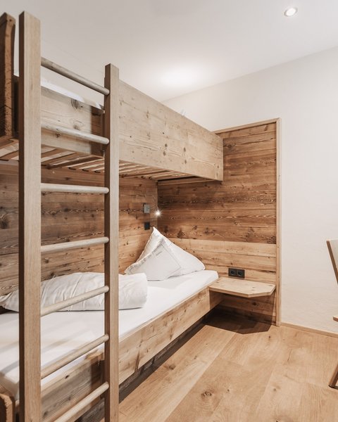 Bilder aus der Sportalm Kleines Zimmer mit Etagenbett und Holzverkleidung