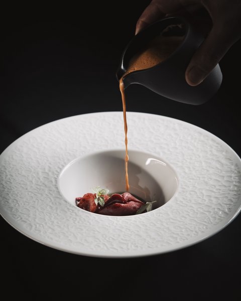 Pictures from Sportalm Sauce poured over gourmet garnish in a decorative white plate
