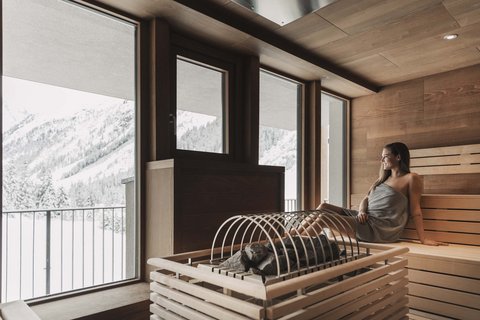 Bilder aus der Sportalm Frau entspannt in Sauna mit Blick auf schneebedeckte Berge