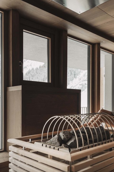 Pictures from Sportalm Woman relaxing in sauna overlooking snowy mountains