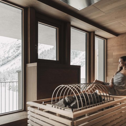 Pictures from Sportalm Woman relaxing in sauna overlooking snowy mountains