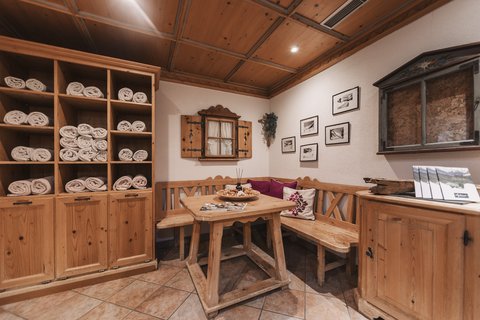 Bilder aus der Sportalm Gemütliche Holzecke mit Tisch, Bank und Regalen voller Handtücher