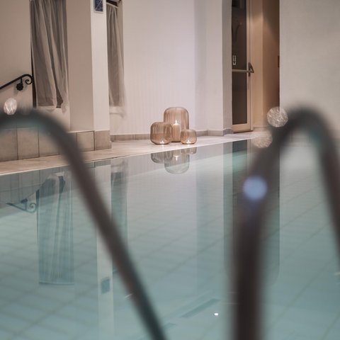 Bilder aus der Sportalm Innenpool mit Kerzen in dekorativen Laternen auf dem Boden