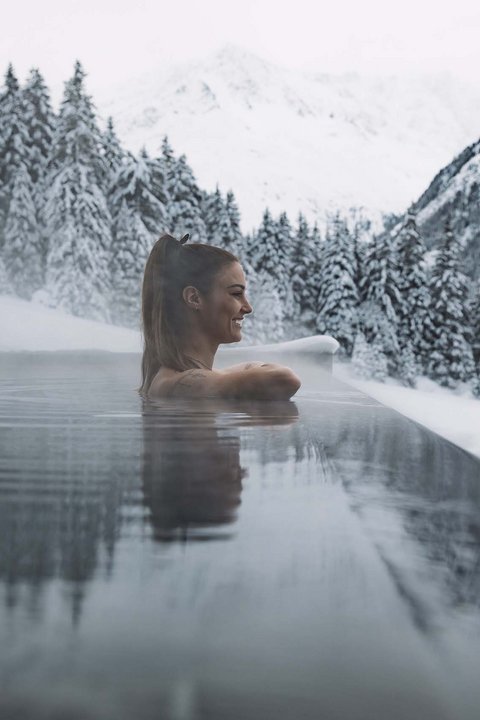 Pictures from Sportalm Woman relaxing in heated outdoor pool with snowy mountains in the background