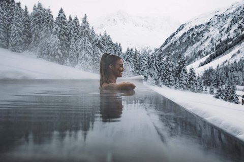 Pictures from Sportalm Woman relaxing in heated outdoor pool with snowy mountains in the background