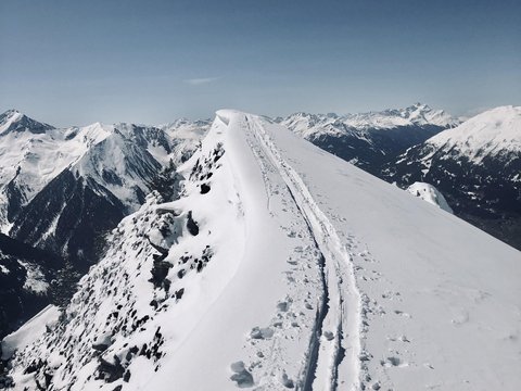 Bilder aus der Sportalm Schnee bedeckter Berggipfel mit Skispuren unter klarem Himmel