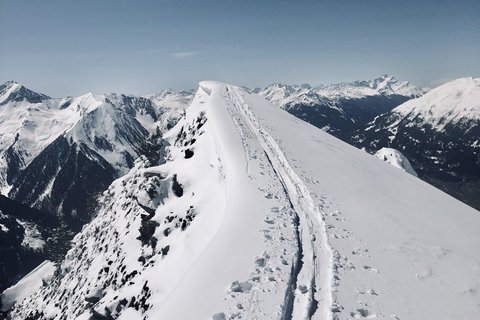 Bilder aus der Sportalm Schnee bedeckter Berggipfel mit Skispuren unter klarem Himmel