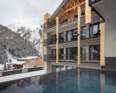 Bilder aus der Sportalm Moderne Lodge mit Pool und verschneiten Bergen im Hintergrund