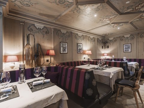 Our restaurant in Pitztal Cozy restaurant with wooden walls, decorated ceilings, and set tables