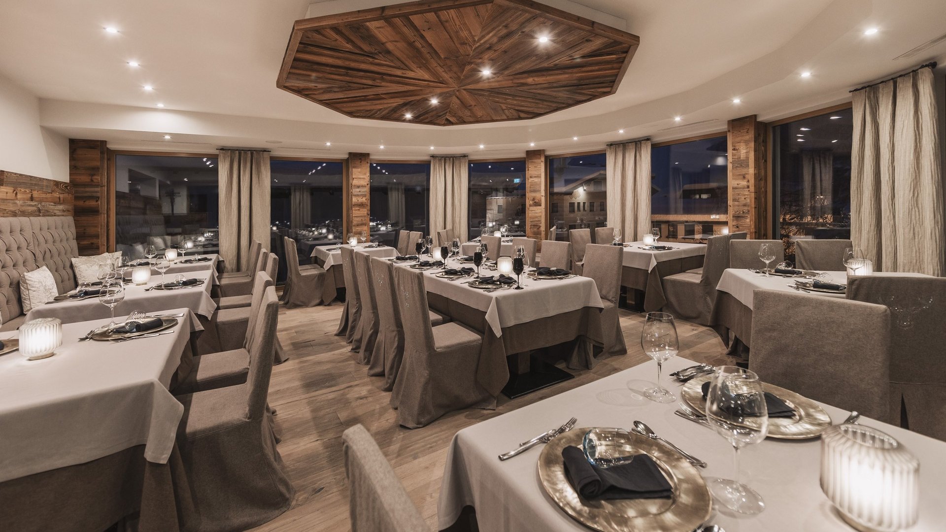 Our restaurant in Pitztal Elegant restaurant with set tables and wooden ceiling