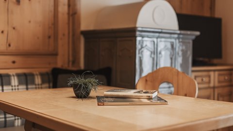 Bilder aus der Sportalm Holztisch mit Büchern und Pflanze in gemütlichem Raum