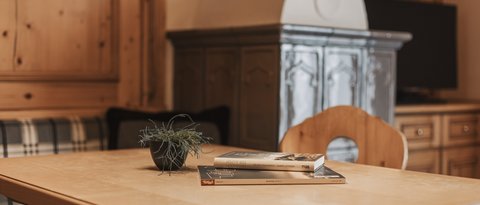 Bilder aus der Sportalm Holztisch mit Büchern und Pflanze in gemütlichem Raum