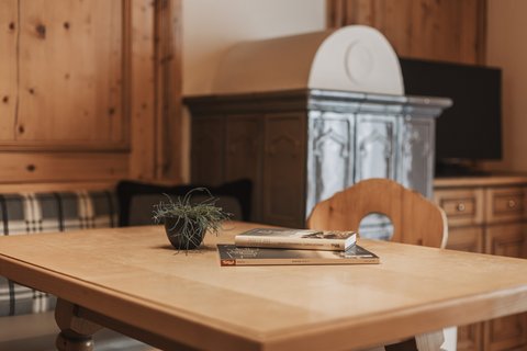 Bilder aus der Sportalm Holztisch mit Büchern und Pflanze in gemütlichem Raum
