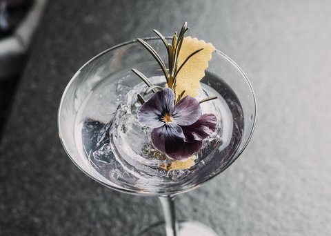 Pictures from Sportalm Cocktail with ice, purple flower and rosemary sprig in martini glass