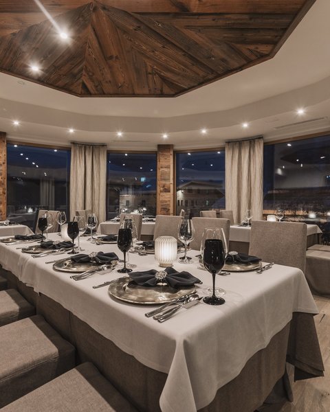 Bilder aus der Sportalm Elegantes Restaurant mit gedecktem Tisch und Holzelementen bei Abendbeleuchtung