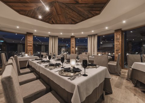 Bilder aus der Sportalm Elegantes Restaurant mit gedecktem Tisch und Holzelementen bei Abendbeleuchtung