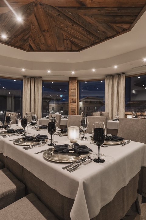 Pictures from Sportalm Elegant restaurant with set table and wooden accents under evening lighting