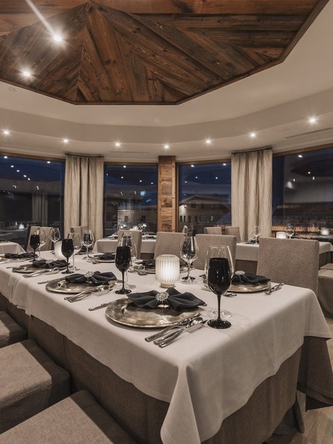 Pictures from Sportalm Elegant restaurant with set table and wooden accents under evening lighting