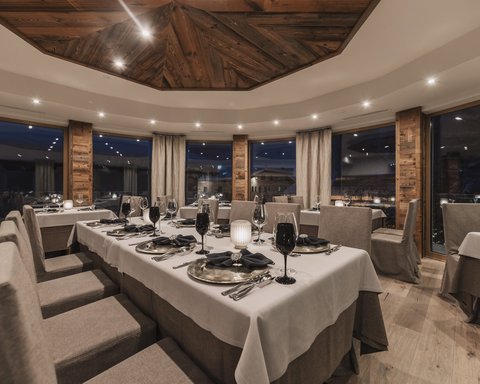 Bilder aus der Sportalm Elegantes Restaurant mit gedecktem Tisch und Holzelementen bei Abendbeleuchtung