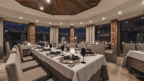Bilder aus der Sportalm Elegantes Restaurant mit gedecktem Tisch und Holzelementen bei Abendbeleuchtung