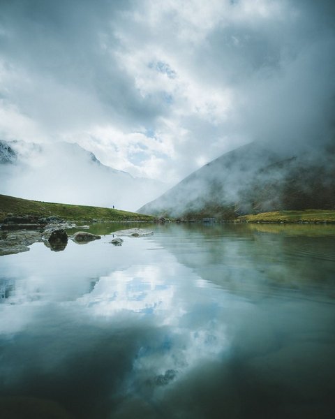 Pictures from Sportalm Mountain lake with reflection and fog on a cloudy day