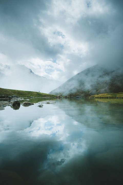 Pictures from Sportalm Mountain lake with reflection and fog on a cloudy day