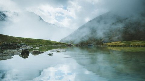 Pictures from Sportalm Mountain lake with reflection and fog on a cloudy day