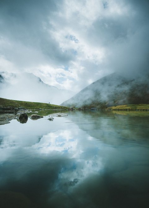 Pictures from Sportalm Mountain lake with reflection and fog on a cloudy day