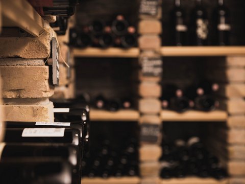 Our restaurant in Pitztal Wine bottles stored on brick shelves in a cellar