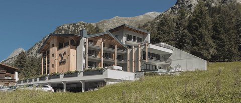Bilder aus der Sportalm Modernes Hotel in den Bergen mit grüner Wiese und klarem Himmel