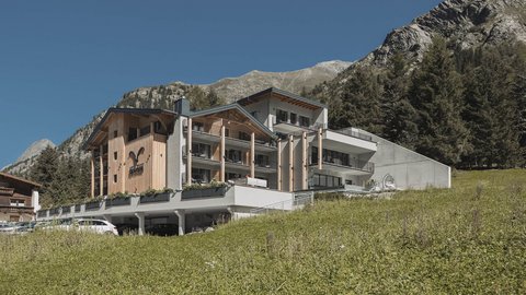 Bilder aus der Sportalm Modernes Hotel in den Bergen mit grüner Wiese und klarem Himmel
