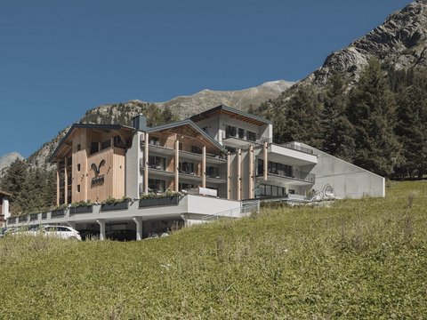 Bilder aus der Sportalm Modernes Hotel in den Bergen mit grüner Wiese und klarem Himmel
