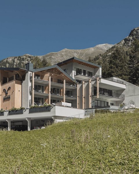 Bilder aus der Sportalm Modernes Hotel in den Bergen mit grüner Wiese und klarem Himmel