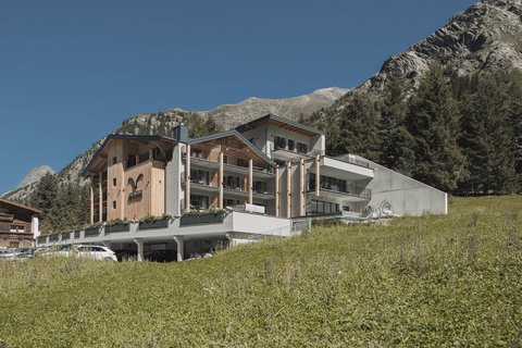 Bilder aus der Sportalm Modernes Hotel in den Bergen mit grüner Wiese und klarem Himmel