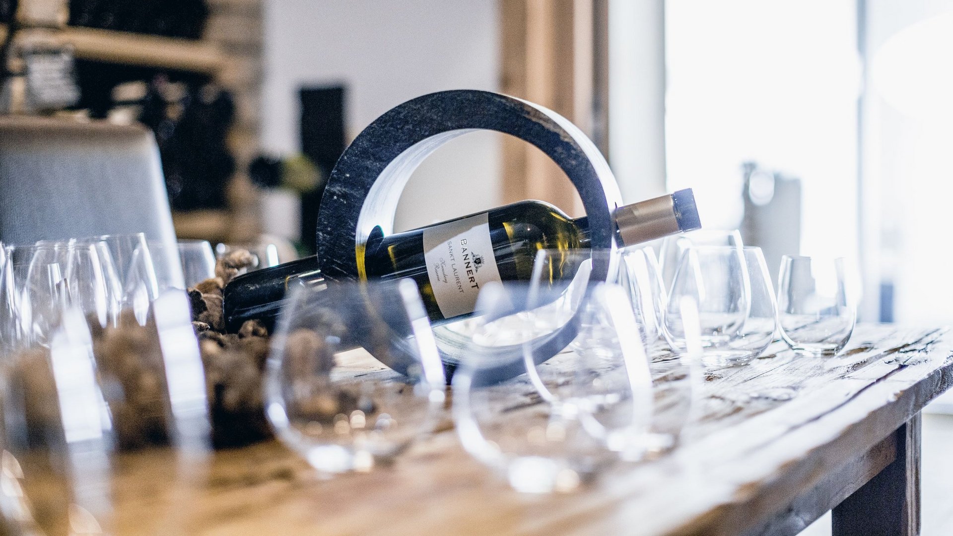 Our restaurant in Pitztal Wine bottle in a circular holder on a table with several wine glasses