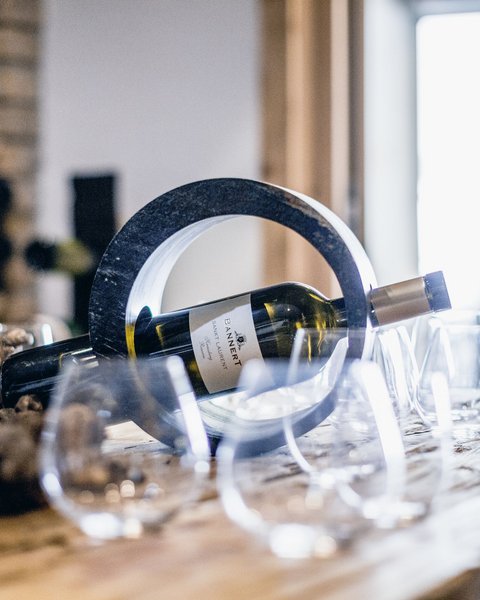 Pictures from Sportalm Wine bottle in a circular holder on a table with several wine glasses