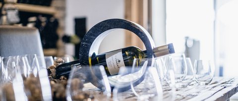 Pictures from Sportalm Wine bottle in a circular holder on a table with several wine glasses