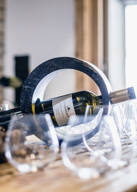 Pictures from Sportalm Wine bottle in a circular holder on a table with several wine glasses