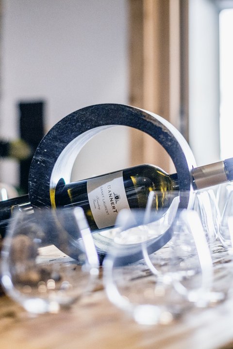 Pictures from Sportalm Wine bottle in a circular holder on a table with several wine glasses
