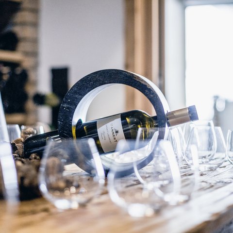 Pictures from Sportalm Wine bottle in a circular holder on a table with several wine glasses