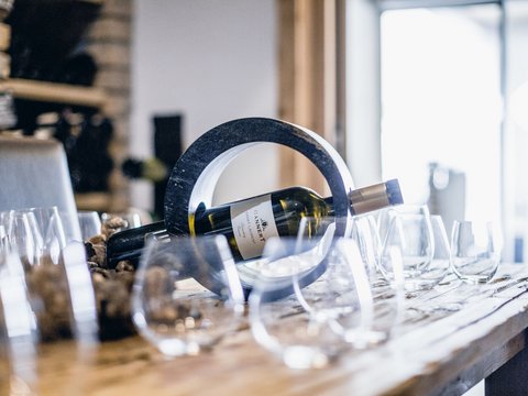 Pictures from Sportalm Wine bottle in a circular holder on a table with several wine glasses