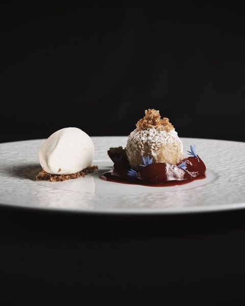 Pictures from Sportalm Elegant dessert with light ice cream and ball dusted with powdered sugar and red sauce