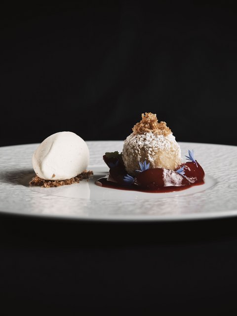 Pictures from Sportalm Elegant dessert with light ice cream and ball dusted with powdered sugar and red sauce