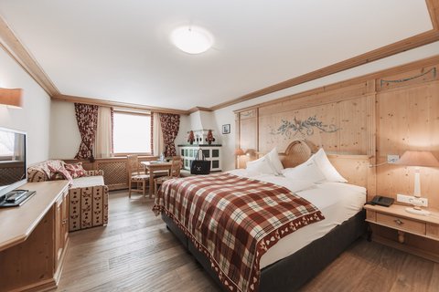 Pictures from Sportalm Bright hotel room with rustic wooden furniture and plaid bedspread