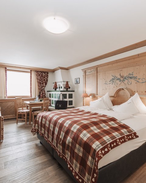 Pictures from Sportalm Bright hotel room with rustic wooden furniture and plaid bedspread