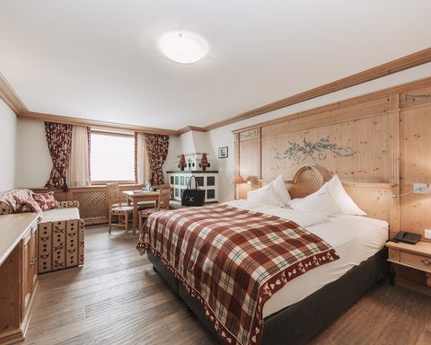 Pictures from Sportalm Bright hotel room with rustic wooden furniture and plaid bedspread