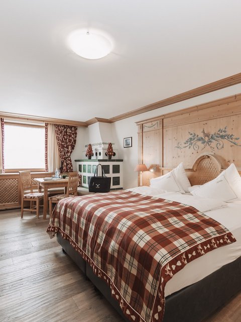 Pictures from Sportalm Bright hotel room with rustic wooden furniture and plaid bedspread