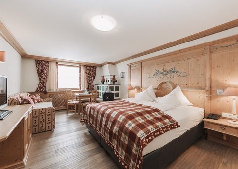 Pictures from Sportalm Bright hotel room with rustic wooden furniture and plaid bedspread