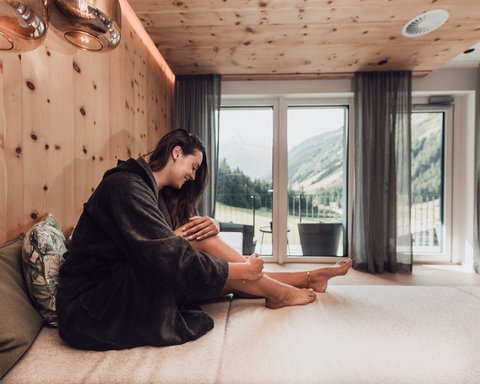 Bilder aus der Sportalm Frau im Bademantel entspannt sich in modernem Zimmer mit Bergblick