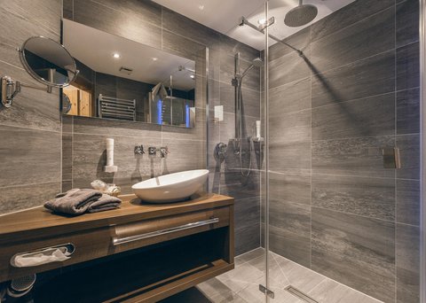 Pictures from Sportalm Modern bathroom with gray tiles, wooden vanity, and glass shower enclosure